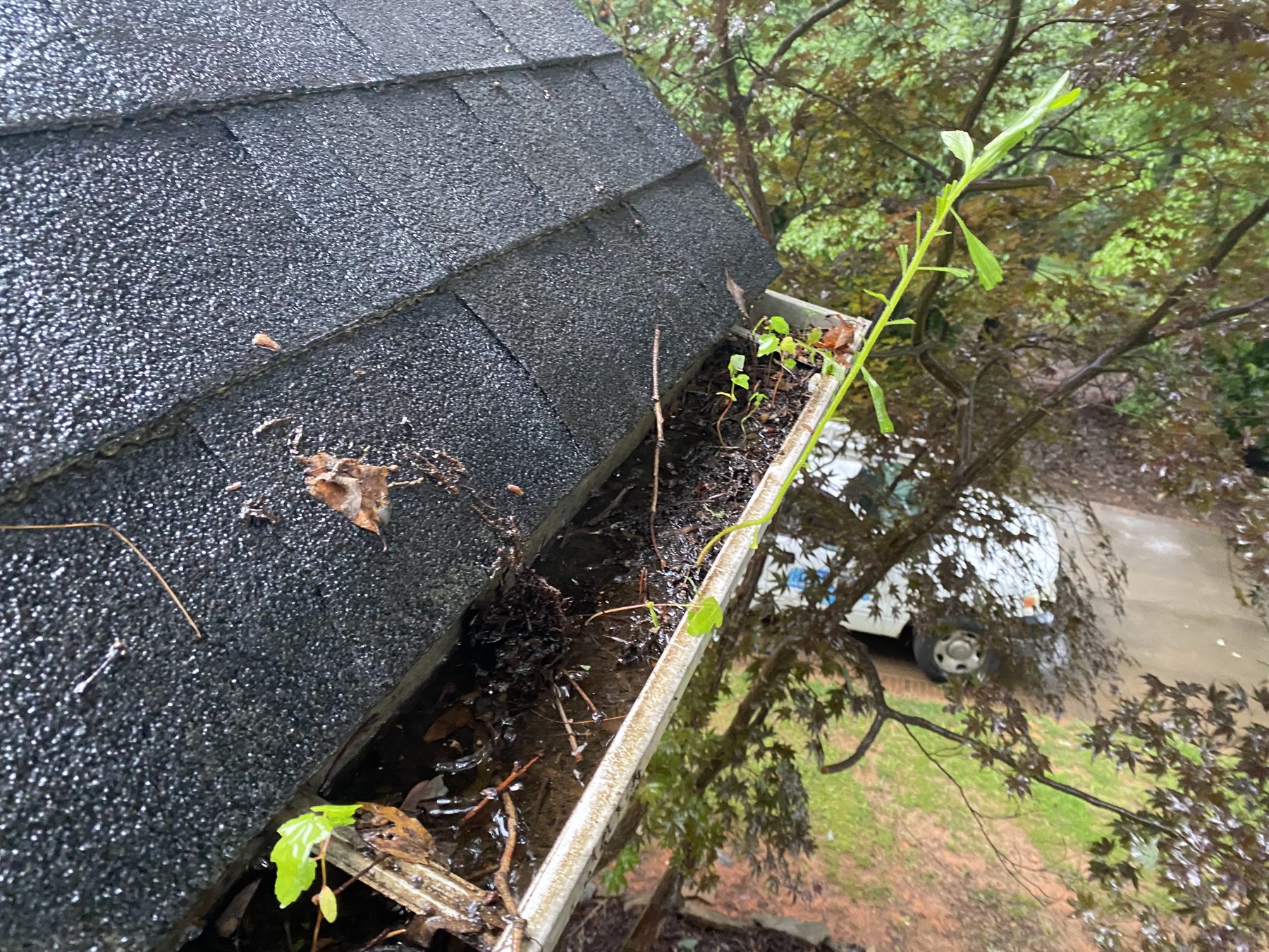 Hickory Gutter Pros technician blowing out and flushing a gutter during cleaning
